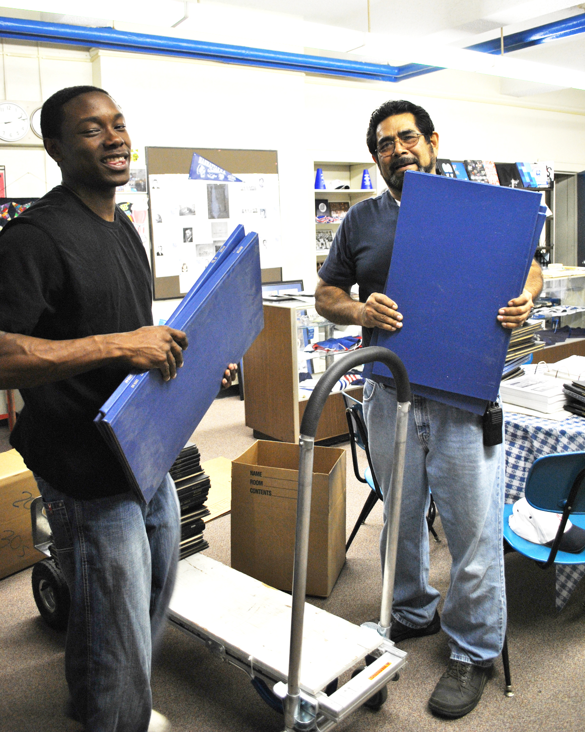 James Hoke and Carlos Gonzales unload bound Mentors they transported from MHS West to the Alumni Center. 