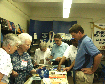 Class of 1944 checks out old programs on visit to Alumni Center.