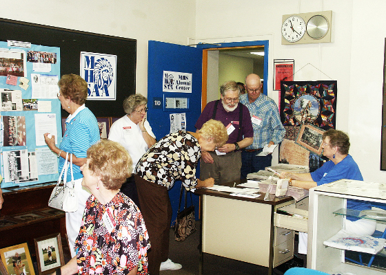 Class of 1954 reunion goers take the time to sign into the Alumni Center.