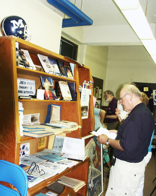 The growing MHSAA Library shelf gets checked out during the Class of 1954 reunion.