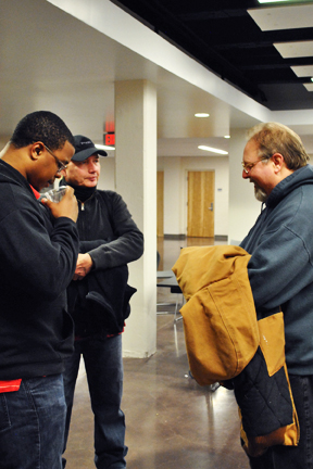 Dawayne Bailey, center, in conversation with school board member Dave Colburn, right, and fan.